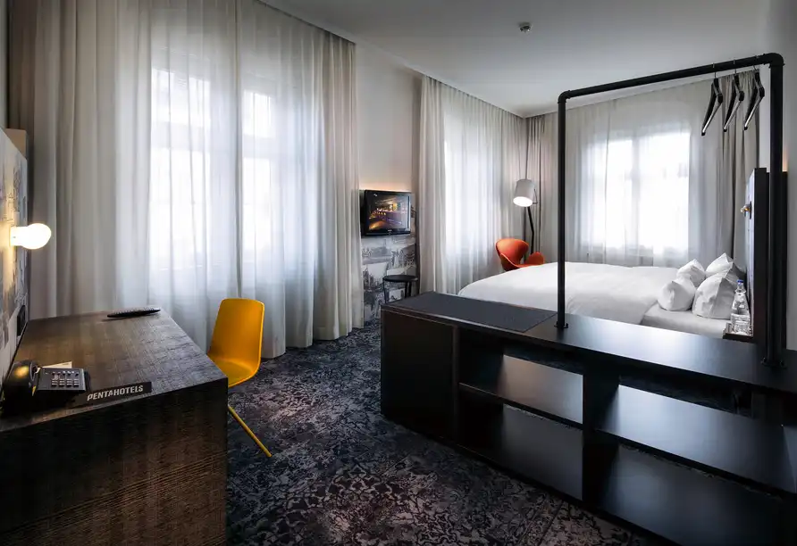 Ein Zimmer im Penta Hotel Altstadt in Braunschweig mit einem modernen Möbelstandort, einem Bett mit weißen Laken und einem