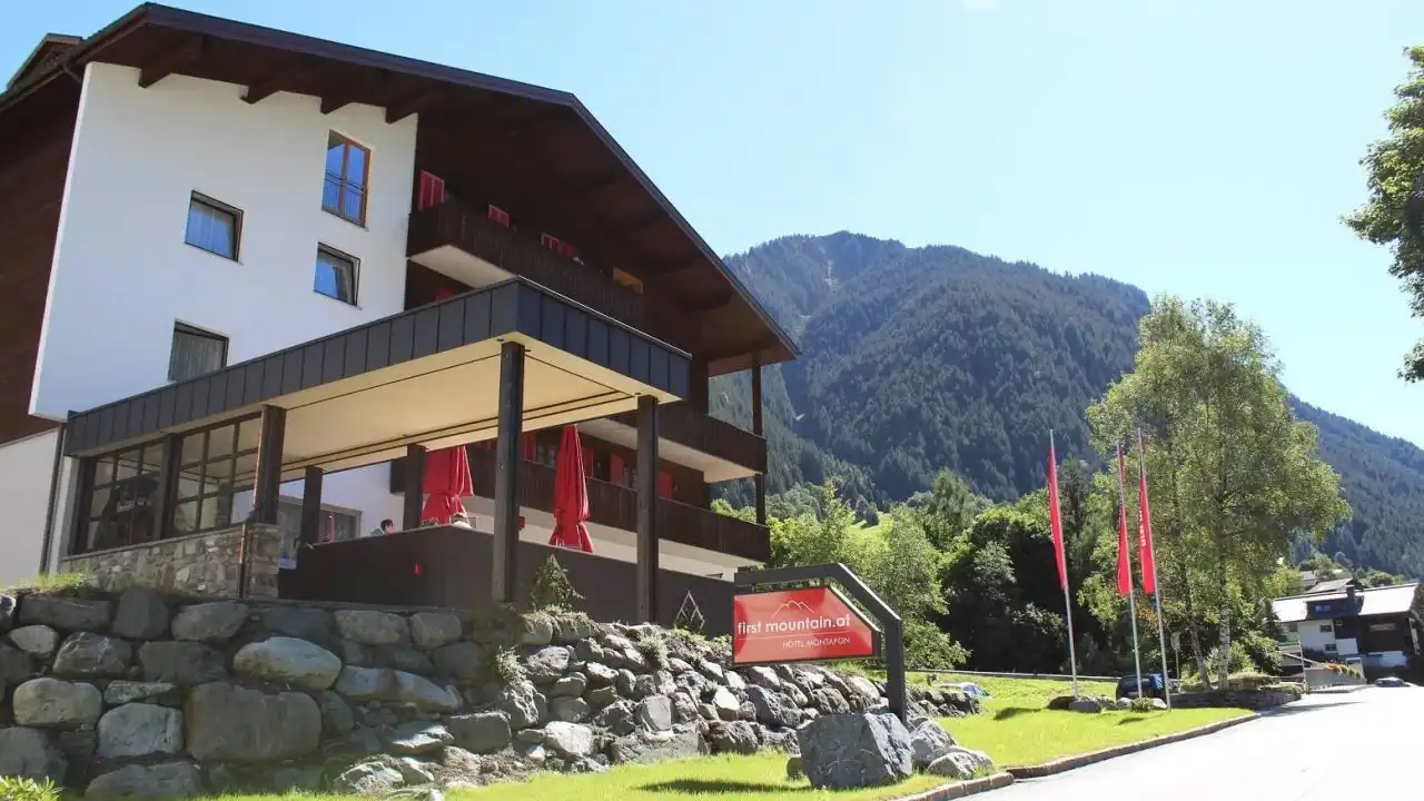 Das First Mountain Hotel Montafon in Gaschurn, Vorarlberg. Die einladende Einladung zeigt ein zweistöckiges Gebäude mit