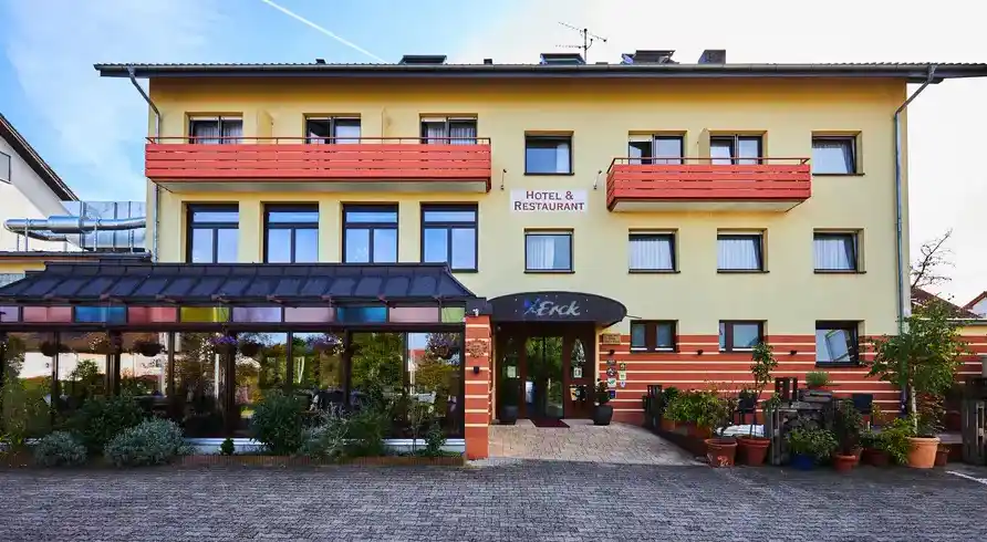 Das Erck. Hotel & Gastronomie in Bad Schönborn. Das Hotel ist ein zweistöckiges Gebäude mit gelben Wänden und roten Details.