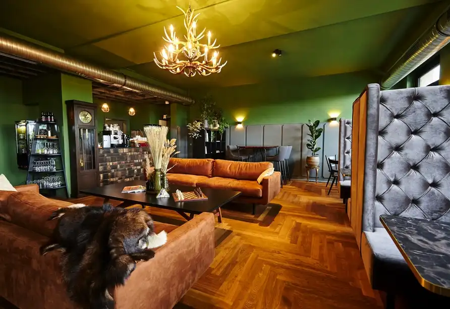 Ein Wohnzimmer mit Holzböden, orangefarbenen Sofas und einem großen Teppich. Ein großes Lichtschirmhintergrund ist auf der
