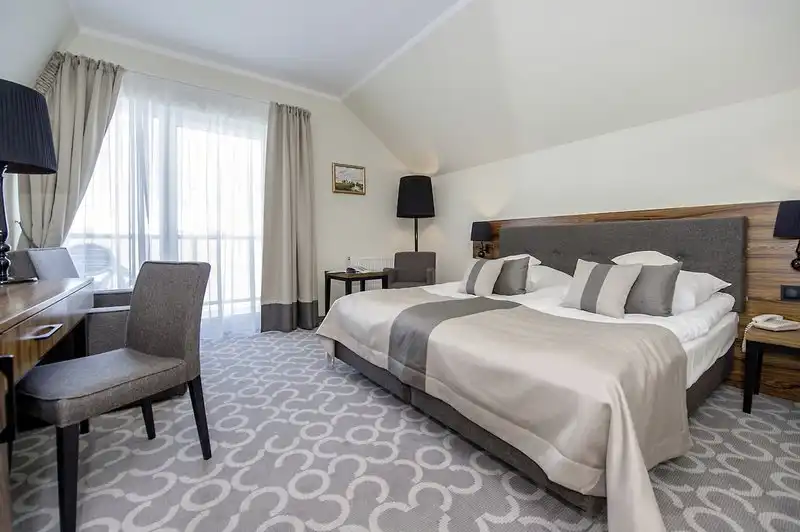 Ein Zimmer im Hotel Sandra & Spa im Ostseebad Pogorzelica. Das Zimmer verfügt über ein großes Bett mit einem hellgrauen und
