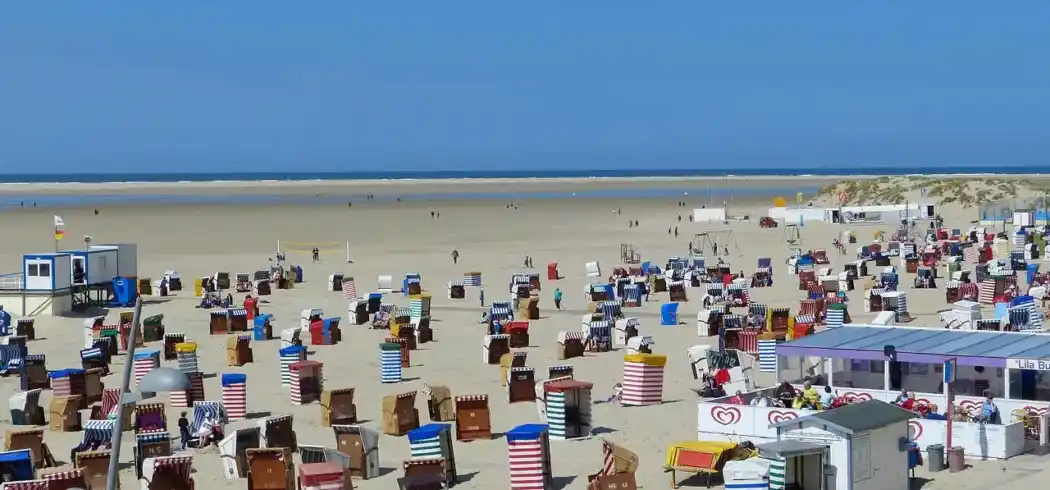 Ein Strand mit vielen Strandkörben und Strandbesitzern, die an einem Strand auf der Nordseeküste zu sehen sind. Der Strand