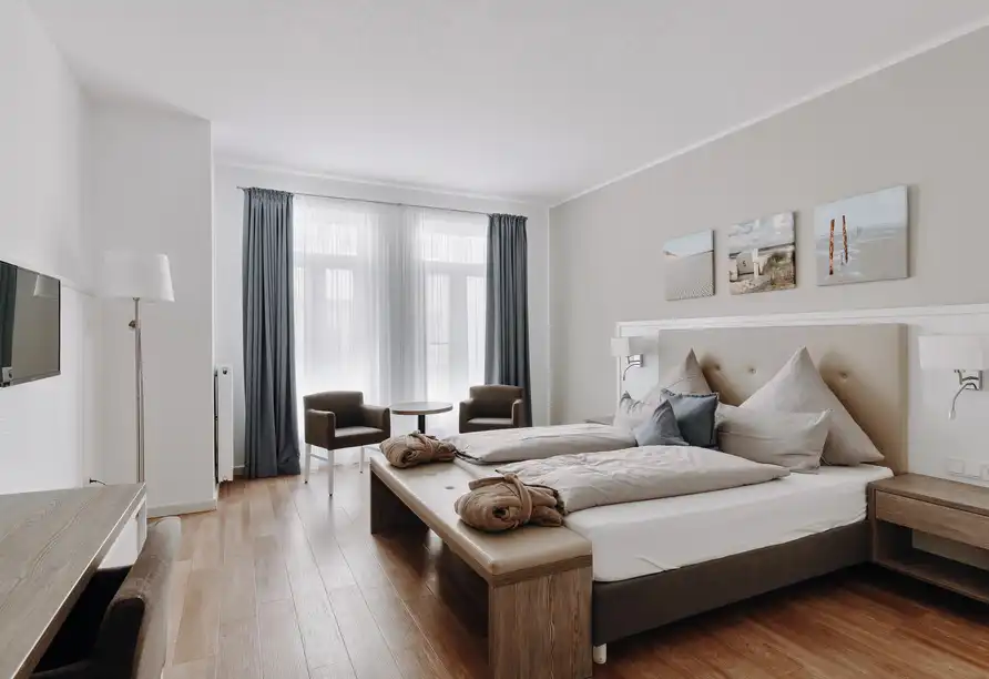 Ein Schlafzimmer mit einem Bett, einem Kommode und einem Arbeitsbereich