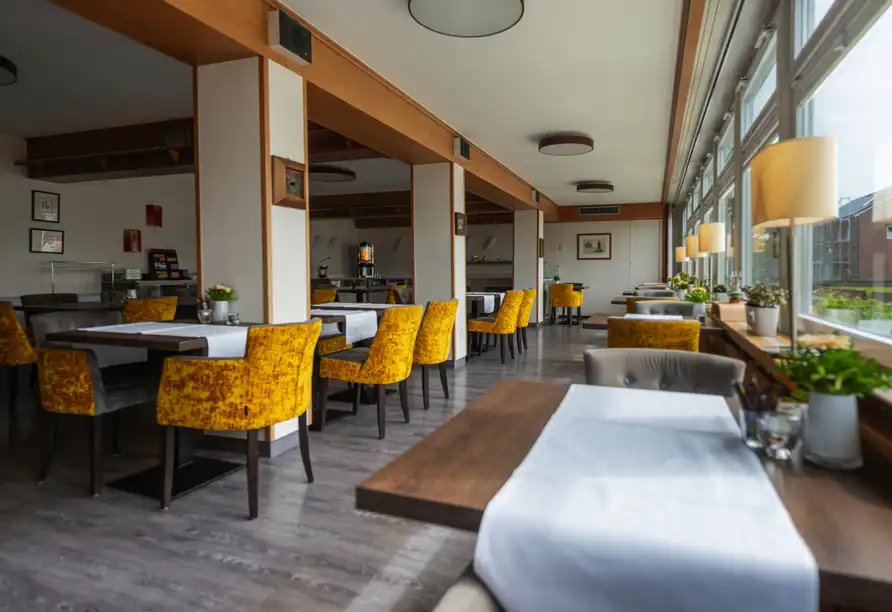 Ein Restaurant mit moderner und gemütlicher Dekoration auf der Nordseeinsel Borkum. Die Einrichtung umfasst Holzböden, weiße