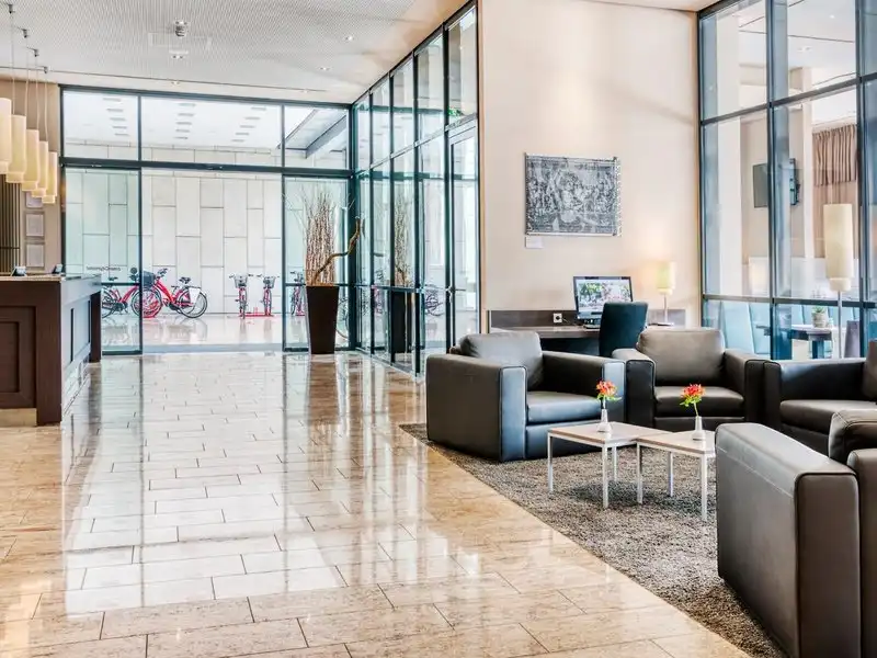 Einen modernen Lobbybereich eines Hotels. Der Raum ist mit großen Fenstern ausgestattet, die einen Blick auf die