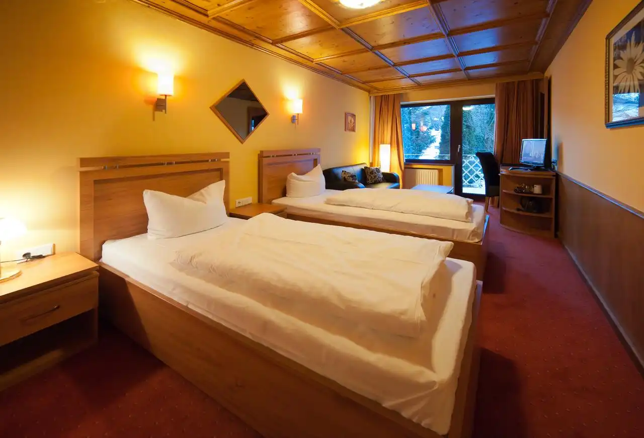 Ein Zimmer im ATLAS GRAND HOTEL**** in Garmisch-Partenkirchen mit Doppelbett und Komfortausstattung