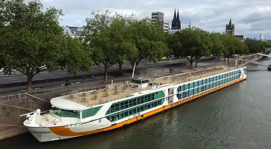 Einen großen Flussboot, das MS VistaSky genannt wird, an der Rheinstrecke in Köln an Land. Das Boot hat mehrere