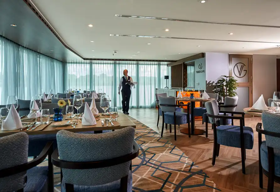Ein luxuriöses Restaurant mit modernem Design. Die Möbel sind in verschiedenen Nuancen von Blau und Braun gestaltet, und die