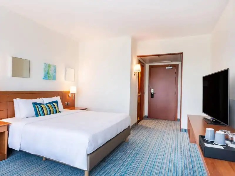 Ein Zimmer im Hotel Courtyard By Marriott Brüssel. Das Zimmer verfügt über ein großes Bett mit weißen Bettwäsche und