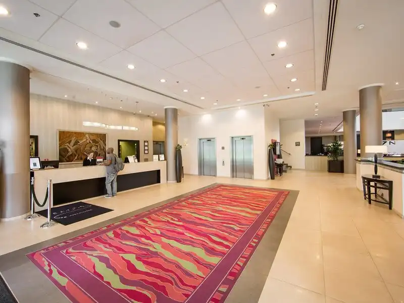Den Eingangsbereich des Courtyard By Marriott Brüssel, einem Hotel in Brüssel. Die Rezeption ist links positioniert, mit