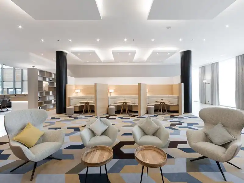 Einen modern gestalteten Hotellobby des Courtyard By Marriott Brüssel. Die Raumgestaltung ist sauber und elegant, mit einem