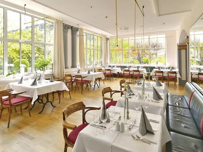 Eine elegante Restaurant-Einstellung im Hotel Kaiserin Augusta in Weimar. Die Zimmer sind mit weißen Tischen und weißen