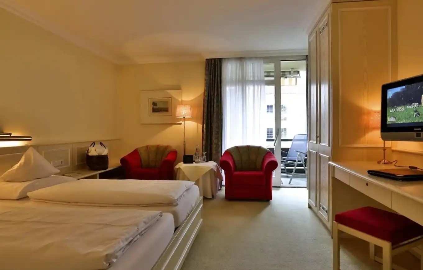 Ein Zimmer im Wunsch Hotel Mürz in Bad Füssing. Das Zimmer verfügt über ein großes Bett mit weißen Bettwäsche und ein paar