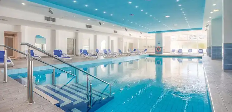 Einen Indoorpool des Hotels Hedera in Rabac, Istrien, Kroatien. Der Pool ist groß und glaserblau, mit metallenen Stangen und