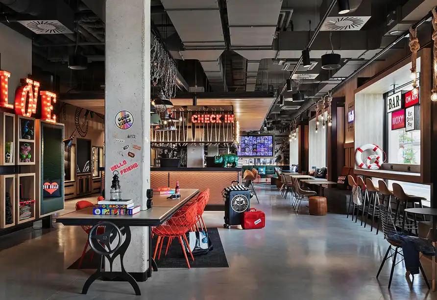 Ein Lounge im Hotel Moxy Bremen mit modernem Ambiente und einer Bar