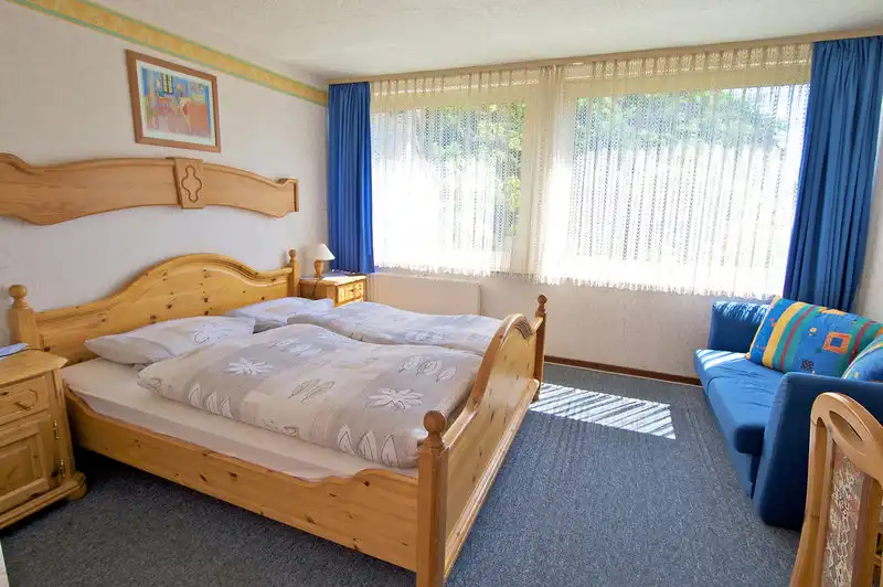 Ein Zimmer im Rheinhotel Wagner in Kamp-Bornhofen. Das Zimmer verfügt über ein großes Bett mit Holzbüchsen und Nachbarn, auf