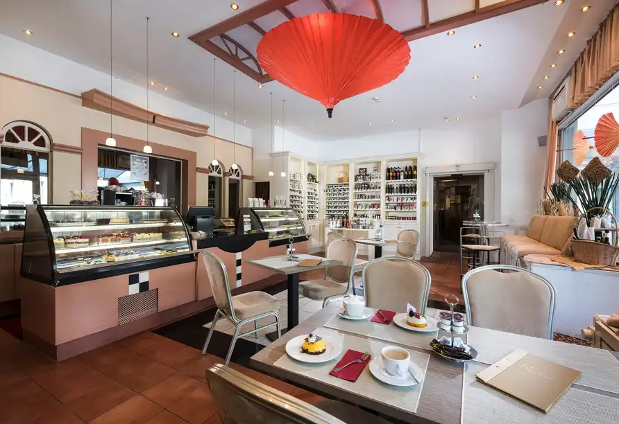 Eine elegante Café- und Restaurantumgebung mit einem modernen Design. Die Dekoration umfasst eine Kombination aus warmem