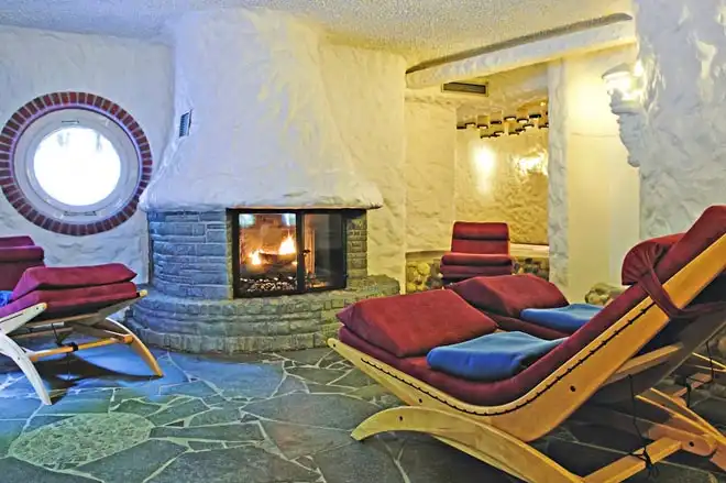 Ein gemütliches Wellnessbereich im Hotel Upstalsboom Landhotel Friesland Varel. Ein bequemer Holzstuhl mit roten und blauen