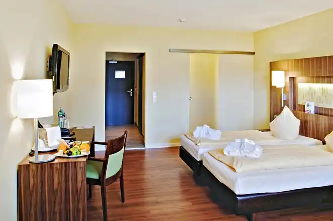 Ein Zimmer im Hotel Upstalsboom Landhotel Friesland Varel. Das Zimmer verfügt über zwei Betten, die nebeneinander platziert
