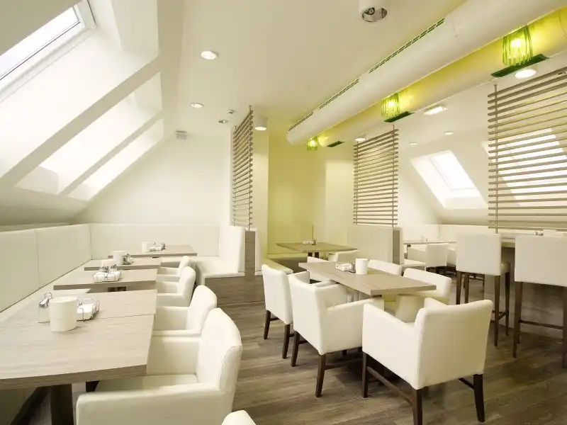 Ein Restaurant im HB1 Design & Budget Hotel Wien-Schönbrunn mit moderner und minimalistischer Dekoration. Die Zimmer sind