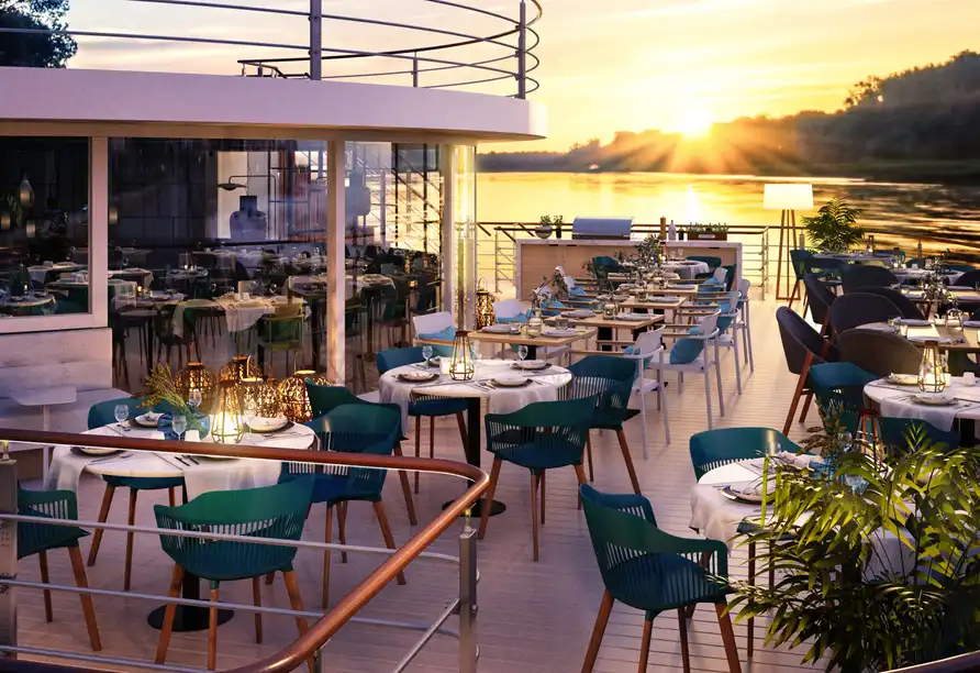 Einen charmanten Außenbereich eines Restaurants auf einem Schiff. Die Tische sind mit weißen Tischenläufern und blauen