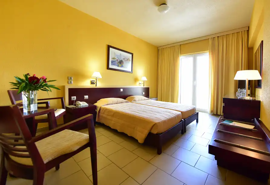 Ein Zimmer im Hotel Reitenberger in Marienbad mit einem Bett, einem Arbeitsplatz und einem Telefon. Die Zimmerwände sind