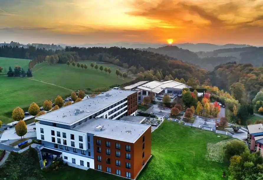 Ein Hotelresidenz im idyllischen Erzgebirge mit Blick auf eine beeindruckende Sonnenuntergangslandschaft. Die Lage bietet