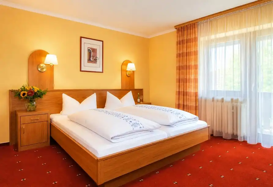 Gemütliches Doppelzimmer mit Holzmöbeln und Balkon im Vital & Wellness Hotel Schürger