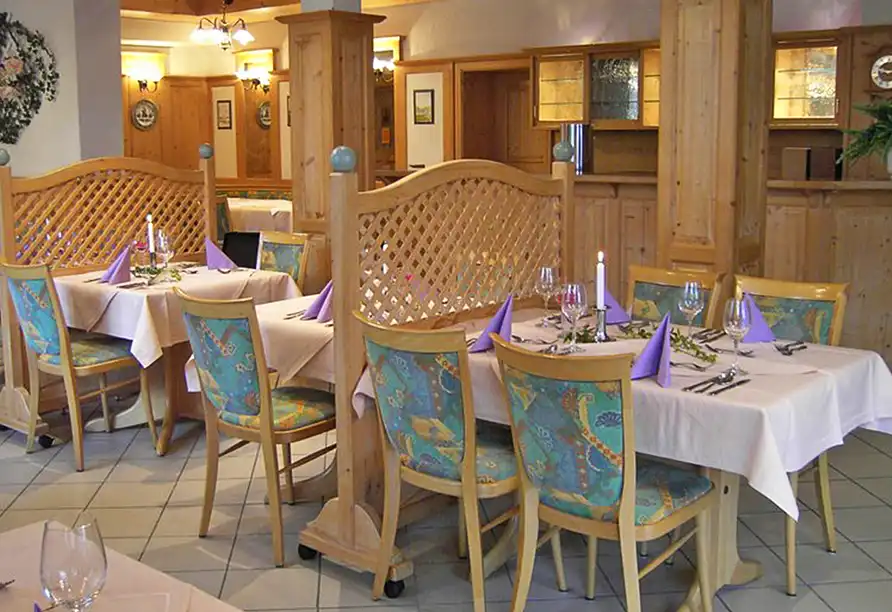 Restaurant mit festlich gedeckten Tischen und gemütlicher Holzeinrichtung im Vital & Wellness Hotel Schürger