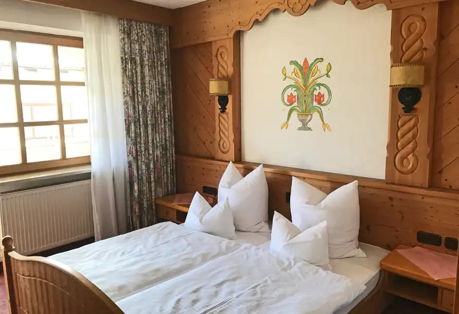 Ein Zimmer im Hotel Genosko in Spiegelau im Bayerischen Wald. Das Zimmer verfügt über ein großes Bett mit weißen Bettwäsche