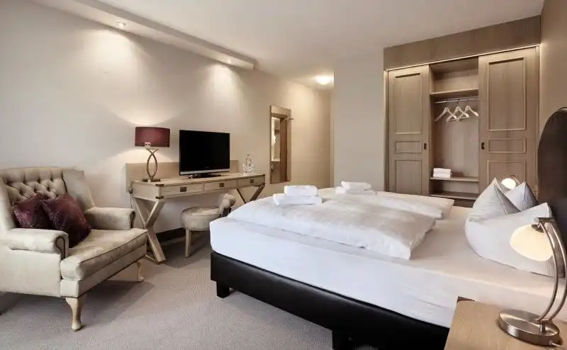 Ein Zimmer im Burghotel am hohen Bogen in Neukirchen mit einem Doppelbett, einem Arbeitsplatz mit Fernseher und einem