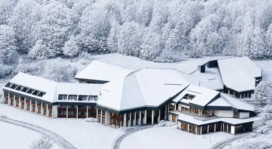 Ein großes Landhaus inmitten eines schneebedeckten Landschafts, das sich in der Sauerland Region befindet. Das Bernstein