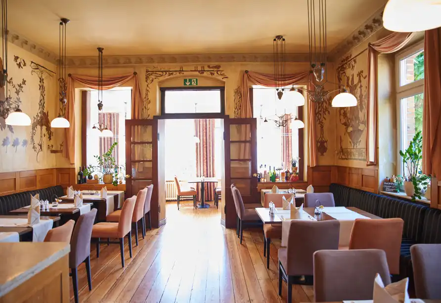 Ein Restaurant mit klassischem Charme im Hotel Eisbach in Ransbach-Baumbach. Das Ambiente ist einladend mit warmem Licht,