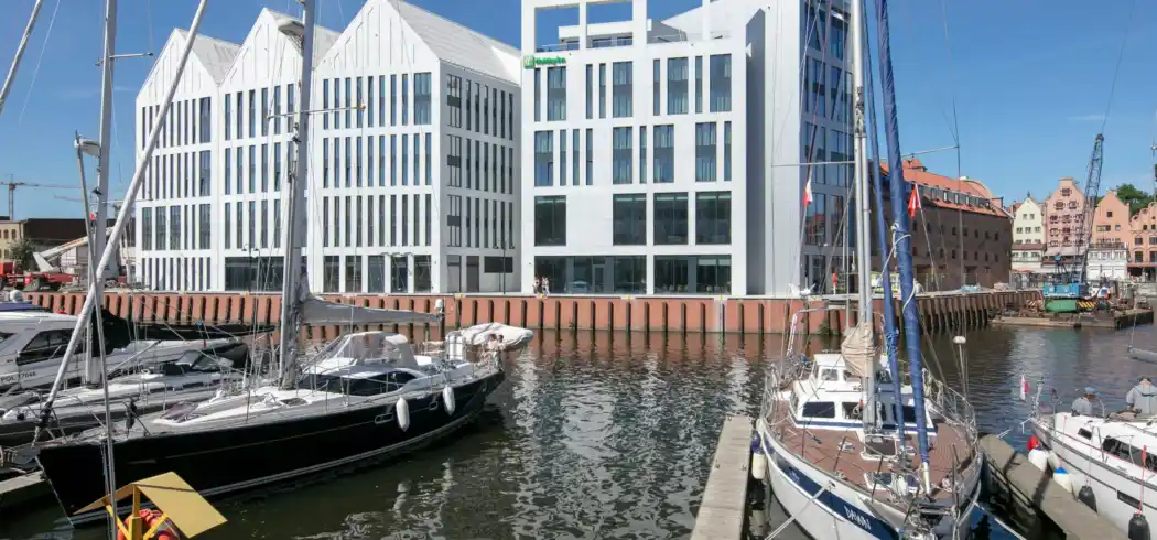 Einen Hafen mit mehreren Booten, darunter ein Segelboot und ein Motorboot, an einem Wharf abgestellt. Im Hintergrund sind