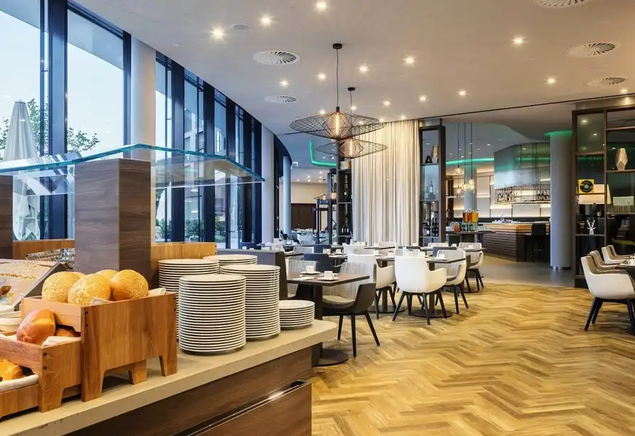 Ein Restaurant im Hotel mit moderner Dekoration und einem Blick auf die Außenbereiche. Die Einrichtung ist gut beleuchtet