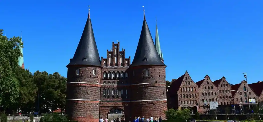 Holstentor in Lübeck vor blauem Himmel und grüner Parkanlage