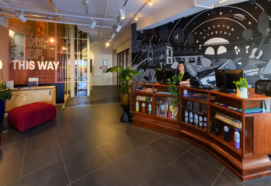 Rezeption im Stayokay Utrecht Center mit Willkommensschriftzug Eat Drink Sleep This Way