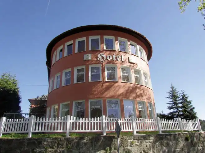 Ein charmantes, runde Hotel mit einer roten Fassade und weißem Fensterrahmen. Das Hotel ist das "Hotel Seeblick" in Wismar,