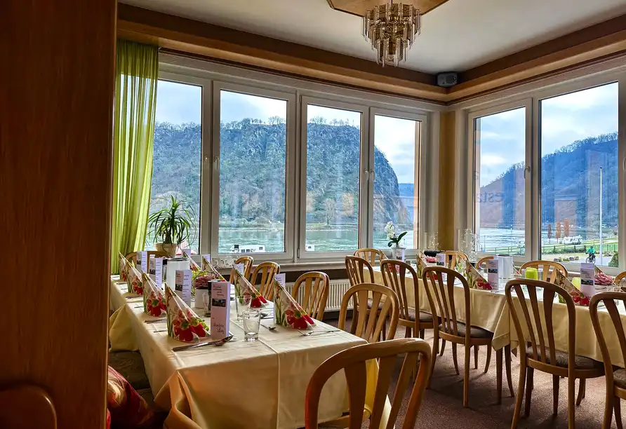 Ein gemütliches Restaurantzimmer im Hotel Loreleyblick in St. Goar. Die Tische sind mit weißen Tischläufern und roten