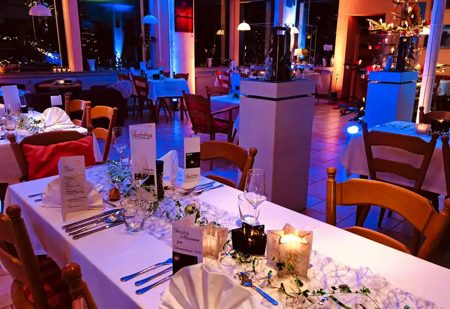 Ein Esszimmer im Hotel Loreleyblick in St. Goar mit weißem Tischläufer, Lichter und Dekorationen. Die Atmosphäre ist