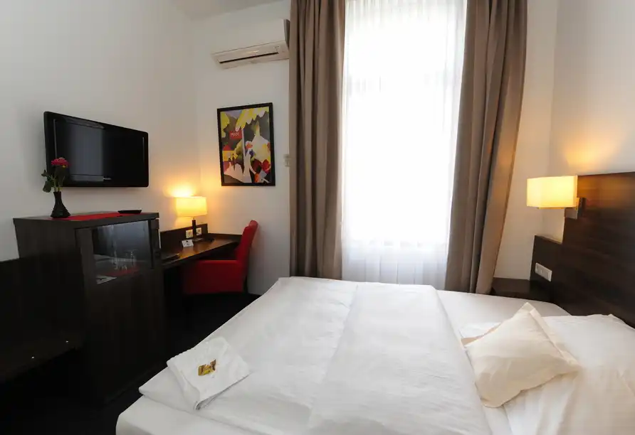 Ein Zimmer im Best Western Hotel Kaiserhof in Bonn-Bad Godesberg mit einem Bett, einem Schreibtisch mit Stuhl und einem