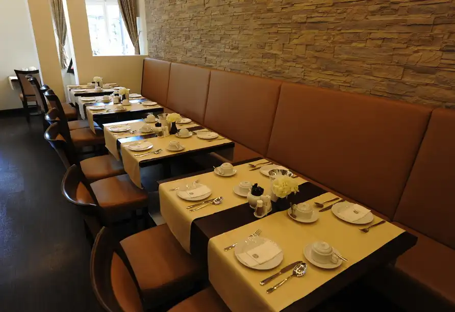 Ein Restaurant mit mehreren Tischen und Stühlen, die für einen Silvesterabend auf dem Rhein reserviert sind. Der Hotelname