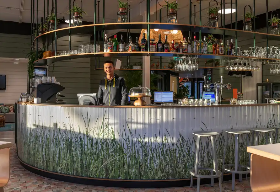 Hotelbar mit Gras-Design und freundlichem Personal im Stayokay Hostel Dordrecht