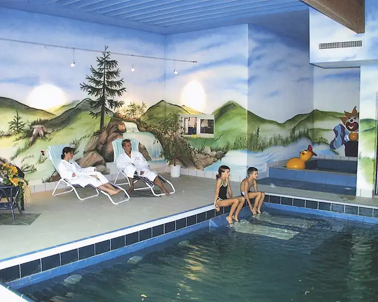 Einen Indoorpool des Hotels Am Pfahl Viechtach. Die Gäste genießen sich in einer ruhigen Atmosphäre, die mit einem