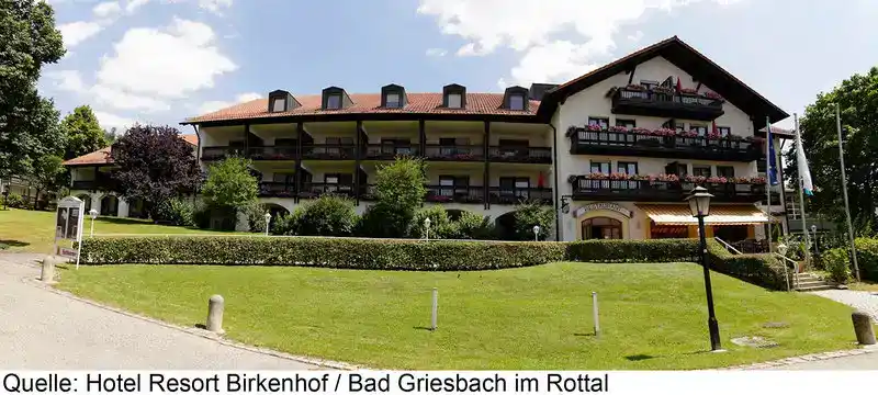 Ein Bild zeigt das Hotel Resort Birkenhof in Bad Griesbach im Rottal. Das mittelalterliche Gebäude mit einem roten Dach und