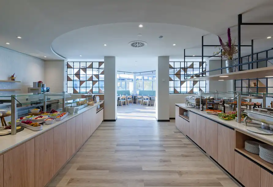 Eine moderne Buffet-Einstellung im FORA Hotel Hannover by Mercure. Die Einrichtung ist gut beleuchtet und hat einen modernen