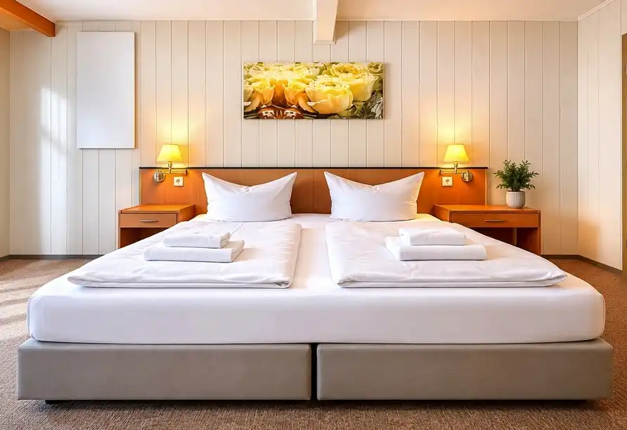 Ein Zimmer im WAGNERS Hotel Steinwiesen mit einem großen Bett, bequem gestaltet und gut beleuchtet. Das Zimmer ist für ein